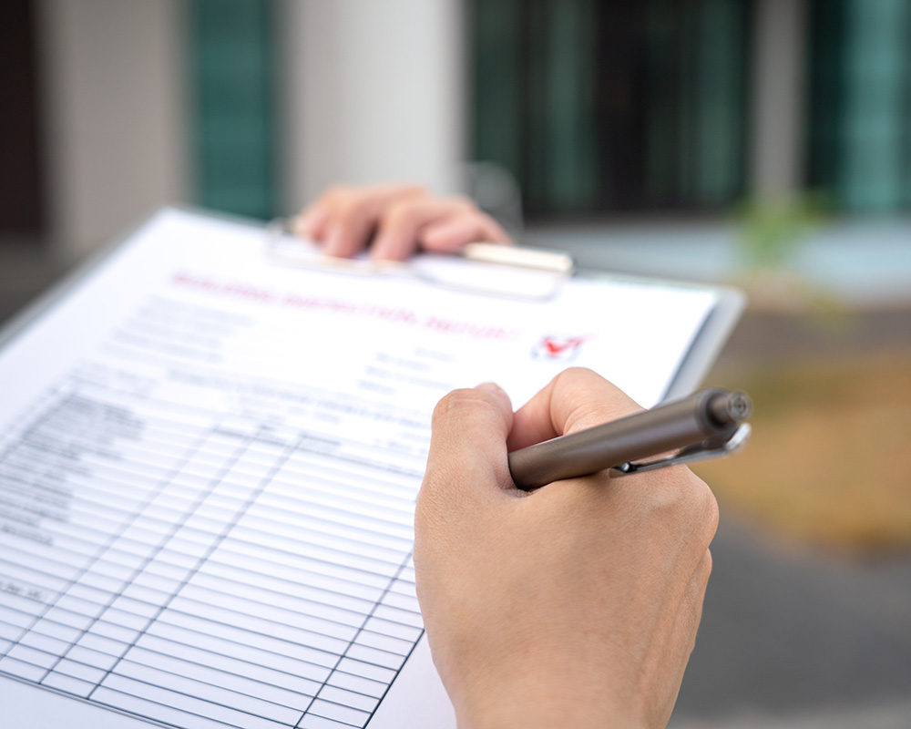 Hand holding a clipboard with a safety checklist, emphasizing OSHA compliance and workplace safety inspections.